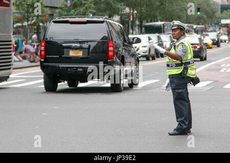 African American police woman is directing traffic during the day in Manhattan. Stock Photo