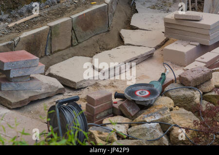 Man cutting stone slabs, concrete slab with an electric grinder Stock Photo