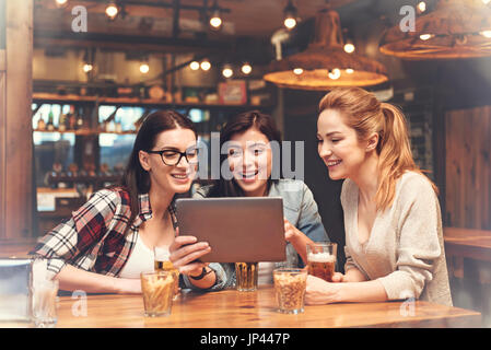 Beautiful brunette sitting between her friends Stock Photo