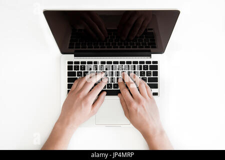 top view of human hands typing on laptop computer isolated on white, wireless communication concept Stock Photo