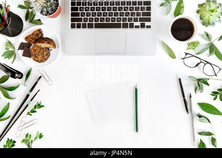 Top view of laptop, blank paper with pencils and cup of coffee at workplace isolated on white, wireless communication concept Stock Photo