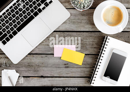 top view of wireless digital devices, coffee cup and blank cards on workplace Stock Photo