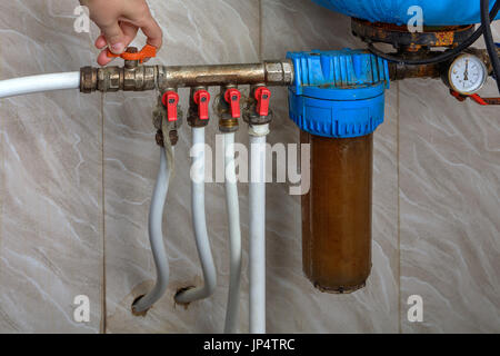 Automatic water supply system, hands turn off the main valve. Stock Photo