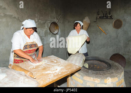 Armenian women preparing the Armenian lavash bread in the traditional tandoor stove, Editorial Use Only, Ararat province, Armenia Stock Photo