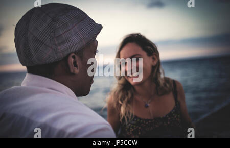 Two people facing each other in front of the ocean. Stock Photo