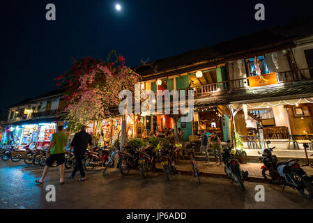 LUANG PRABANG, LAOS - MARCH 11, 2017: Wide angle picture of people inside of coffee shops and restaurants  at Sisavangvong Road, located in the olf Qu Stock Photo