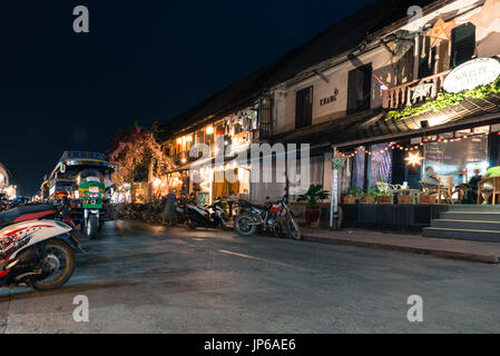 LUANG PRABANG, LAOS - MARCH 11, 2017: Long exposition picture of coffee shops, restaurants and tuk tuk at Sisavangvong Road, located in the olf Quarte Stock Photo