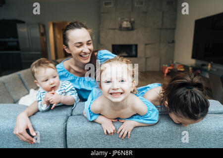 Mom, two daughters and a little son on the couch Stock Photo