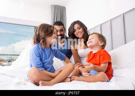 Children playing on parents bed wearing pajamas Stock Photo