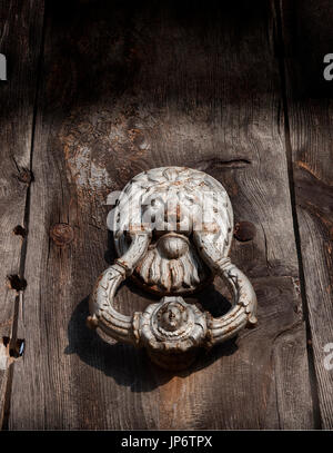 Ancient knocker on cracked wood door Stock Photo