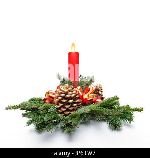 Table christmas centerpiece with a red color candle lit and fir tree leaves. White background. Stock Photo