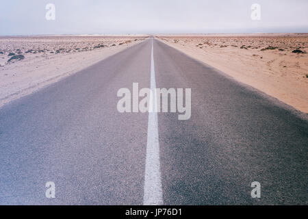 Vintage instagram style image of an empty desert road in Dakhla, Western Sahara desert, Morocco. Stock Photo