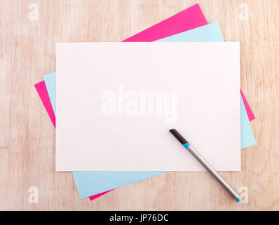 Top view of colorful papers with blank white on the top and marker on wooden desk Stock Photo