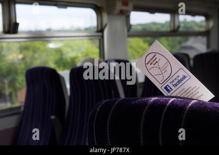 Northern train interior with marketing card for the North Cheshire Rail Users Group - find us on Facebook logo in the seat back and views from train. Stock Photo