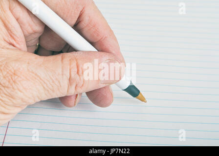 Male left hand ready to start writing on lined paper Stock Photo