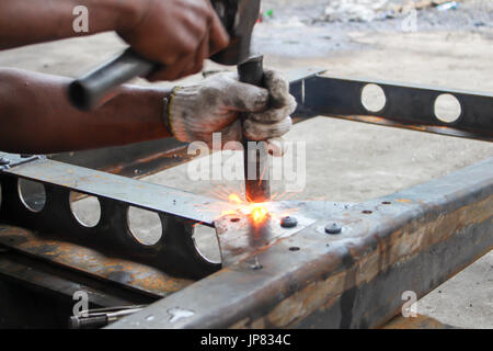 Hammering glowing steel - to strike while the iron is hot Stock Photo