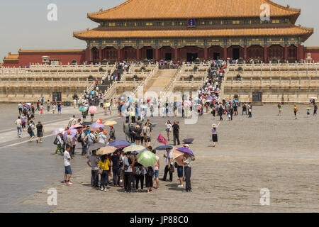 Tourists holding shade umbrellas approaching the Hall of Supreme Harmony in Forbidden City in Beijing China Stock Photo