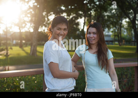Portrait of two young Thai women at a park Stock Photo