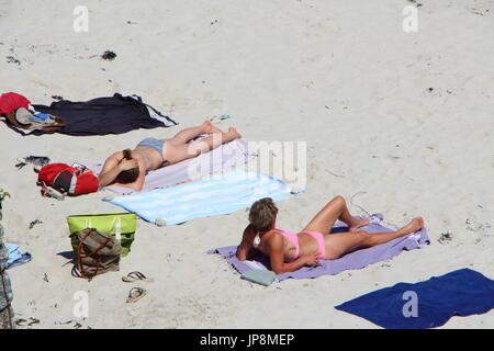 LANDUNVEZ - FRANCE, MAY 26 : Two women in bikini sunbathing on the sand of a beach in Brittany, May 26, 2017 Stock Photo