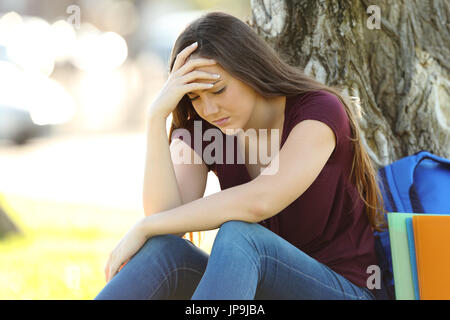 Single concerned student lamenting alone outdoors in a park Stock Photo