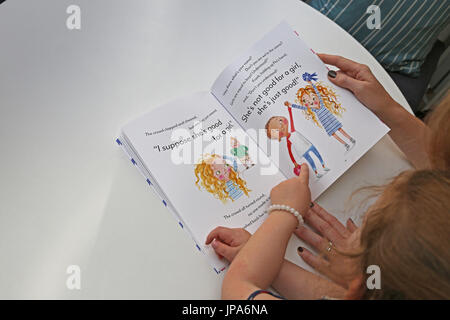 A mother and daughter read from a book by new children's author Suzanne Hemming Stock Photo