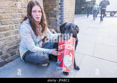 England, London, Homeless Girl with Dog Selling The Big Issue Magazine Stock Photo