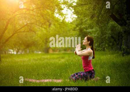 Portrait of sporty woman practicing yoga, standing in mountain with arms up  pose in tropical garden. Stock Photo by prathanchorruangsak