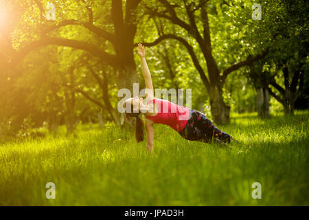 Woman exercising yoga in side plank pose. Stock Photo