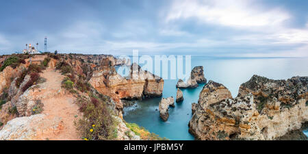 Panorama of cliffs and lighthouse surrounded by the ocean at dawn Ponta Da Piedade Lagos Algarve Portugal Europe Stock Photo