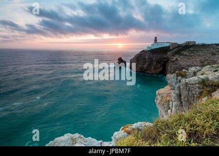 Pink sky at sunset frames the lighthouse overlooking the Atlantic Ocean Cabo De Sao Vicente Sagres Algarve Portugal Europe Stock Photo