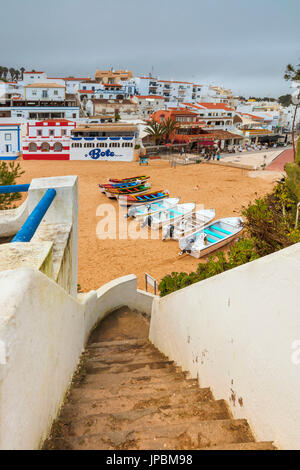 Boats on sandy beach frame the typical fishing village of Carvoeiro Lagoa Municipality Algarve Portugal Europe Stock Photo