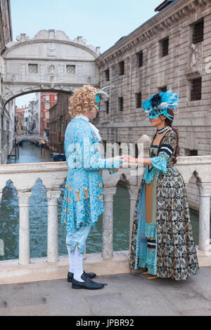 Europe, Italy, Veneto, Venice. Couple in carnival fancy dress near the Bridge of Sighs (Ponte dei Sospiri) Stock Photo