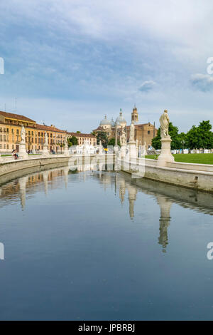 Statues on the Prato della Valle, Padua, Italy reflected in the calm water of the canal surrounding the elliptical square lined with historic townhouses and buildings, italy, europe Stock Photo