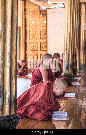 Nyaungshwe, Inle lake, Shan State, Myanmar.  Novice monks praying at the Shwe Yaunghwe Kyaung. Stock Photo