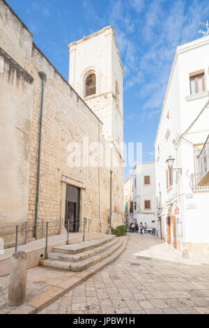 Bell tower and typical alley of white houses in the old town Polignano a Mare province of Bari Apulia Italy Europe Stock Photo