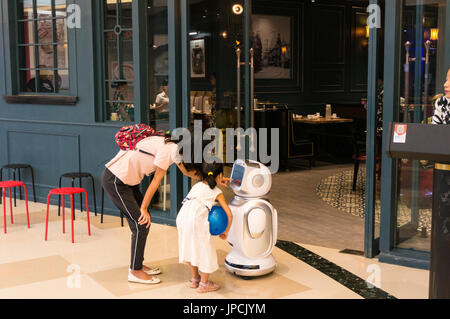 Mother and young girl interacting with restaurant robot in Shenzhen, China Stock Photo