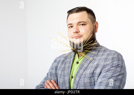 serious fat man with pasta in beard Stock Photo