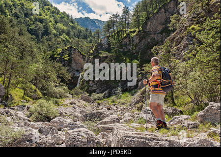 Mature hiker about 60 years old. Trekkink on mountains. Active retirement. Healthy Lifestyle. Stock Photo