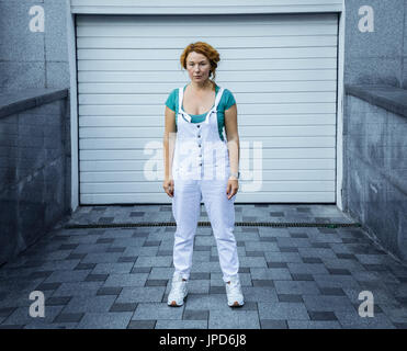 Red haired middle aged adorable woman posing on camera, dressed in green t-shirt Stock Photo