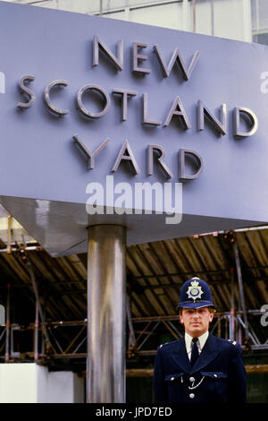 A policeman stands beside the sign outside the former New Scotland Yard building, located in Victoria, London. England, UK, Circa 1980's Stock Photo