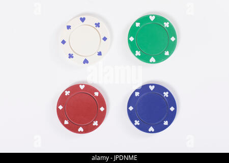 Four casino gambling chips isolated on white in red, green, blue and white for the different denominations issued in a casino Stock Photo