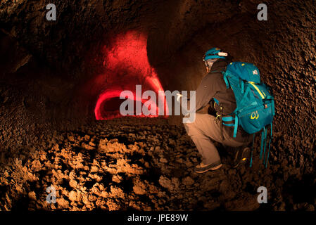Etna volcano, Catania, Sicily, Italy. Man exploring an underground lava cave of the Etna volcano Stock Photo