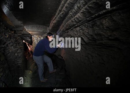 An abandoned slate mine in Italy with a speleologist, Fontanabuona valley, Genoa, Italy, Europe Stock Photo