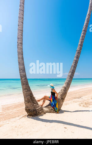 Juanillo Beach (playa Juanillo), Punta Cana, Dominican Republic. Woman under high palm trees on the beach (MR) Stock Photo