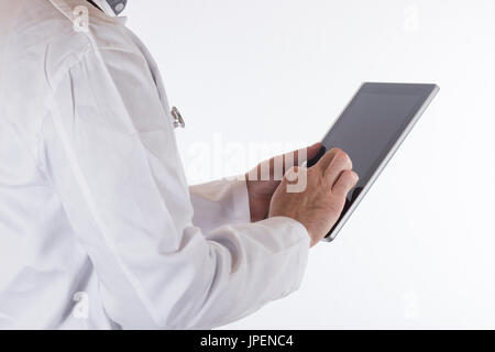 Doctor in a lab coat using a tablet computer navigating the blank black touchscreen with his finger in a close up view on white Stock Photo