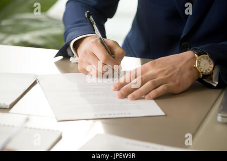 Male hand putting signature on contract, signing document, close Stock Photo