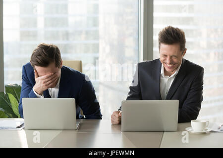 Two businessmen laughing out loud, good positive emotions at wor Stock Photo