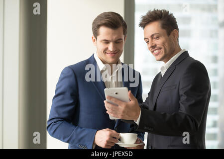 Smiling businessman holding digital tablet showing something fun Stock Photo