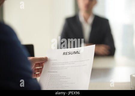 Job interview in office, focus on resume, close up view Stock Photo