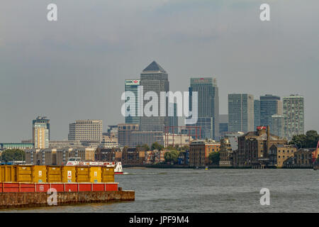 The Skyscrapers of Canary Wharf tower over The River Thames as seen from the riverbank in Bermondsey, London Stock Photo